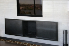 Designer: Pembrooke & Ives. Bronze fireplace surround.